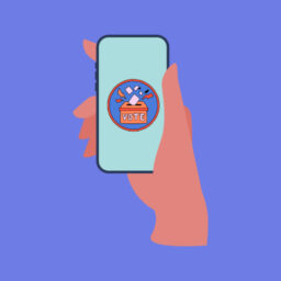 Hand holding a phone that has a an illustration of a vote ballot box, with a blue background
