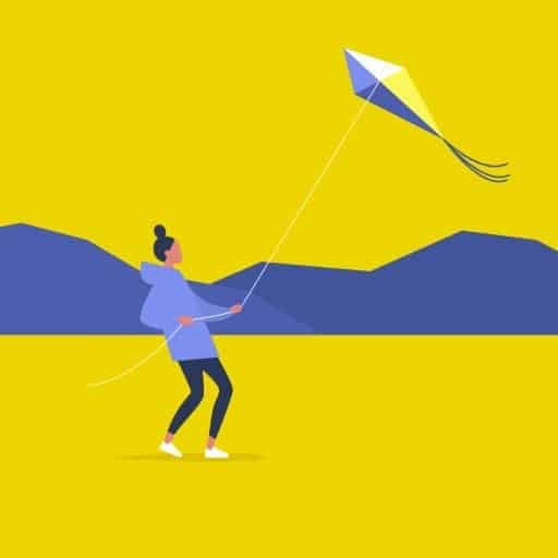 young person with bun wearing hoodie flying a kite